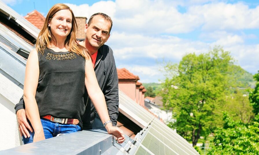 Hausbesitzerpaar ist glücklich mit ihrer Solaranlage auf dem Dach